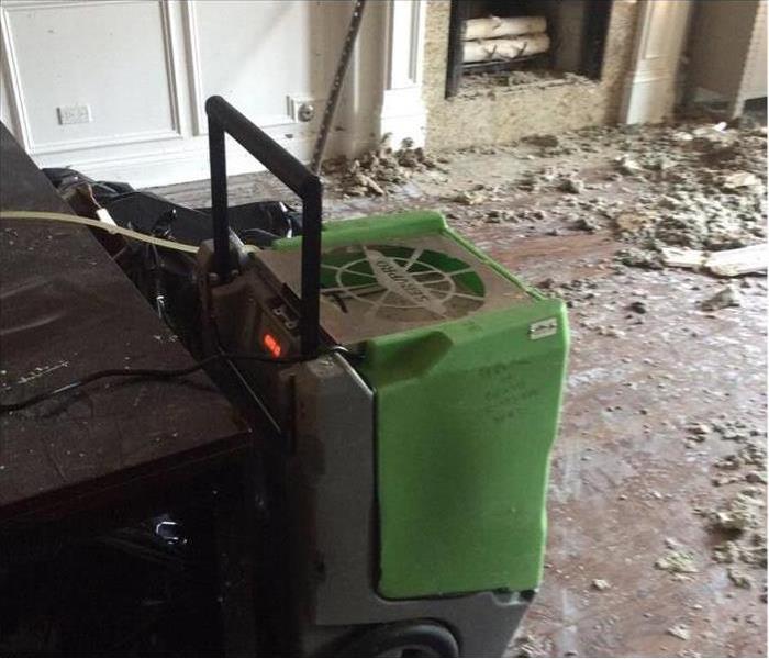 SERVPRO dehumidifier in front of a fireplace with the debris removed.