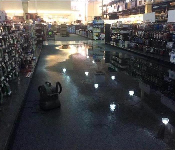 Wet carpet in a store isle with standing water water.