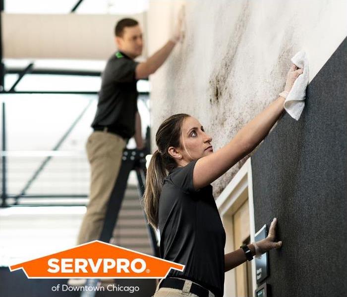 SERVPRO Professionals are cleaning a soot-damaged wall. 