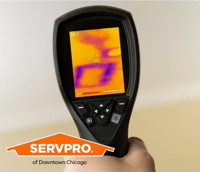 A SERVPRO technician uses an infrared camera to locate water inside the wall of a structure.